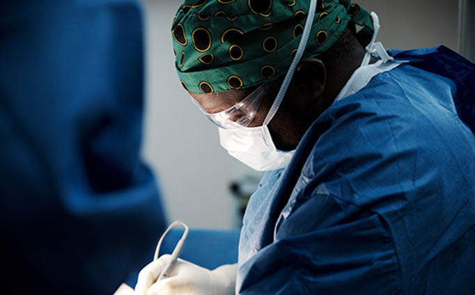 An MSF doctor performs surgery on a patient out of view.